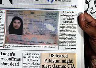 Oszama bin Ladennek, az al-Kaida nemzetközi iszlamista terrorszervezet vezetője ötödik feleségének újságban megjelent útlevelét nézi egy férfi a pakisztáni Karacsiban 2011. május 5-én. A 27 éves nőt R
