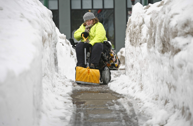 Havat lapátol a kerekesszékes nő