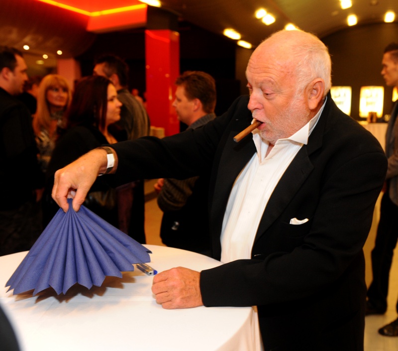 Andy Vajna, a muskátlik mögül kihajoló ember