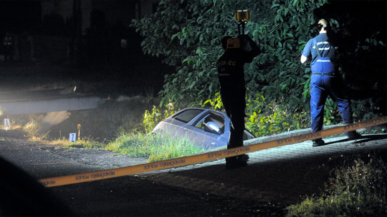 endőrök helyszínelnek egy árokba borult személyautó mellett Gödöllőn 