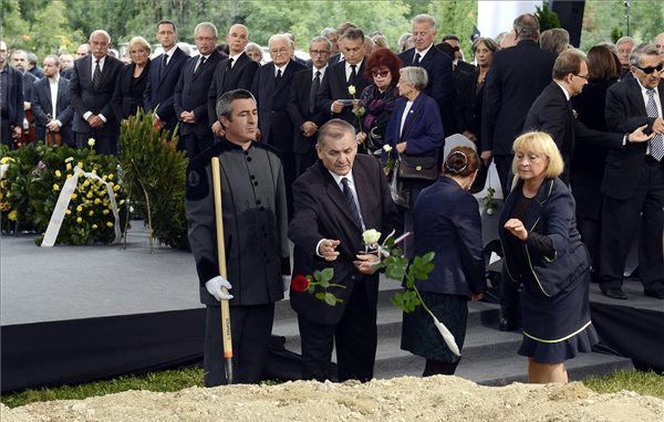 Lezsák Sándor rózsát dob Csoóri Sándor sírjába - Fotó: MTI - Illyés Tibor 