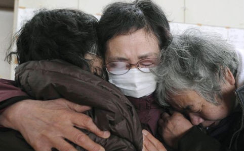 Túlélők a földrengés után Szeretteik elvesztését sirató nők gyászolnak együtt Keszennumában. (MTI/AP/Kyodo News) 