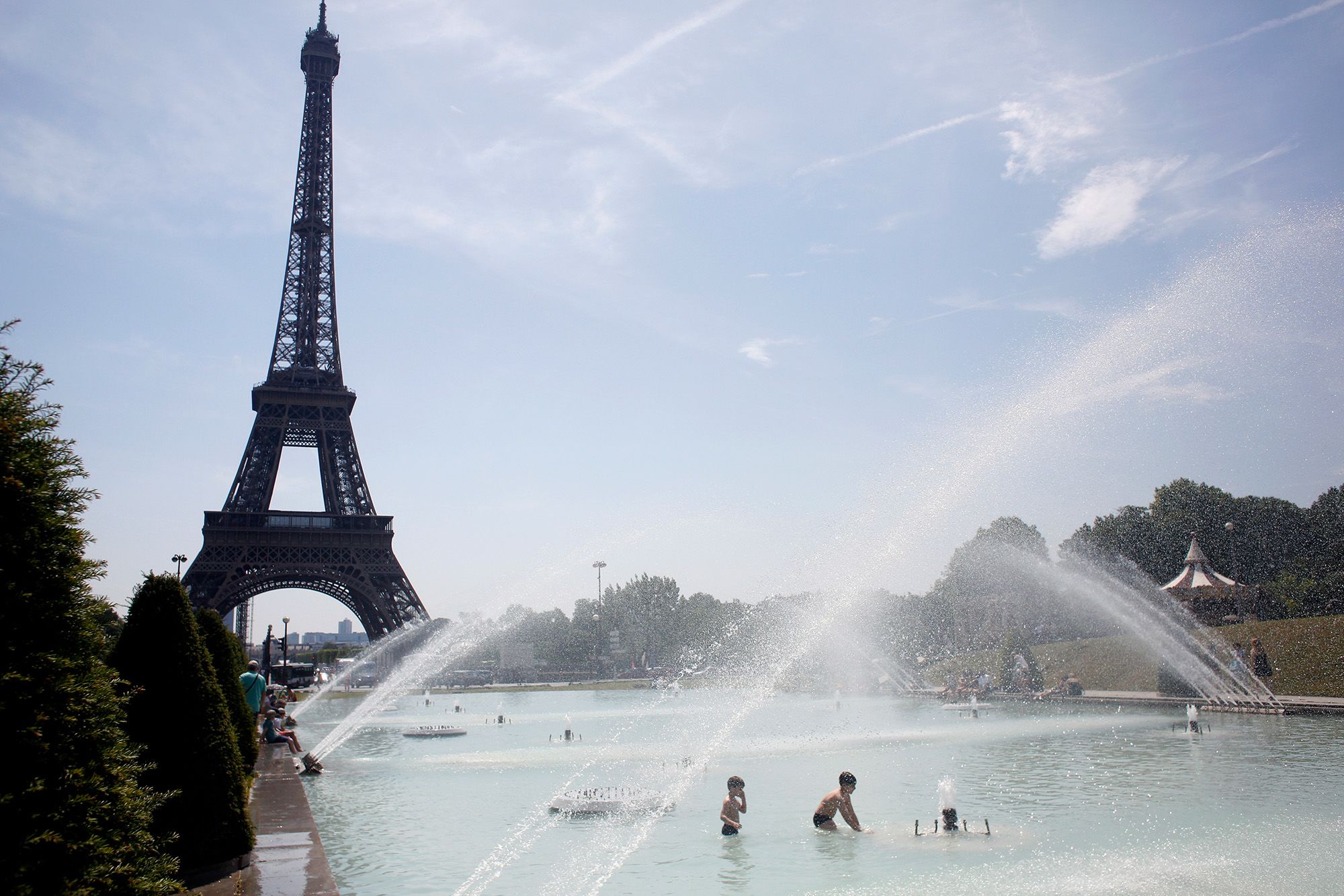 Emberek hűsölnek a párizsi Trocadéro tér szökőkútjában 2019. június 25-én. A francia fővárosban a hármas szintű hőhullámtervet léptették életbe, tizenhárom parkot tartanak nyitva éjszakánként is, hogy az emberek hűsölni tudjanak. Fotó: MTI/AP/Thibault Camus