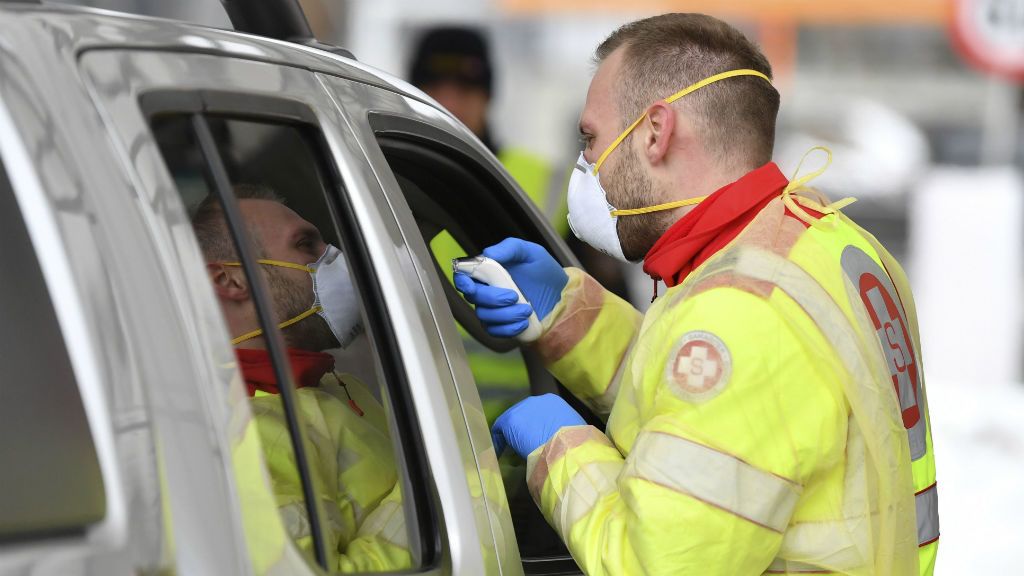 Egészségügyi dolgozó egy utas testhőmérsékletét méri az ausztriai Gries am Brenner település és az osztrák-olasz határ közötti parkolóban 2020. március 10-én. Az osztrák határon az Olaszországból érkező járműveket szúrópróbaszerűen ellenőrzik a koronavírus-járvány terjedése miatt.MTI/AP/Kerstin Joensson