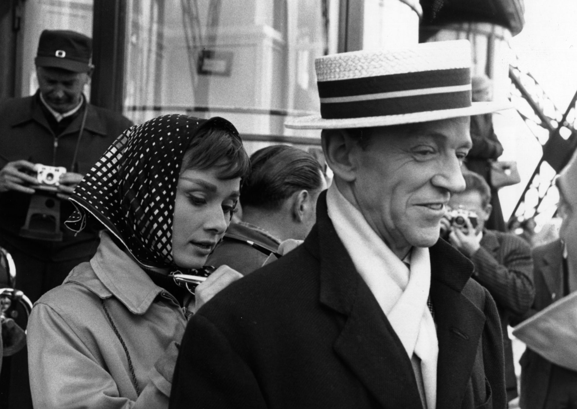 Audrey Hepburn épp filmbéli partnerének Fred Astaire-nek a hátát használja íródeszkának a Funny Face forgatásán, 1956-ban.