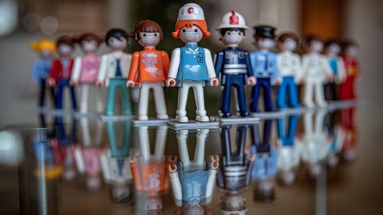 Védőmaszkot viselő Igrácek figurák a világszerte Pokeeto márkanéven forgalmazott játékfigurákat gyártó cseh vállalat, az Efko-karton Nove Veseli-i üzemében - Fotó: MTI/EPA/Martin Divisek