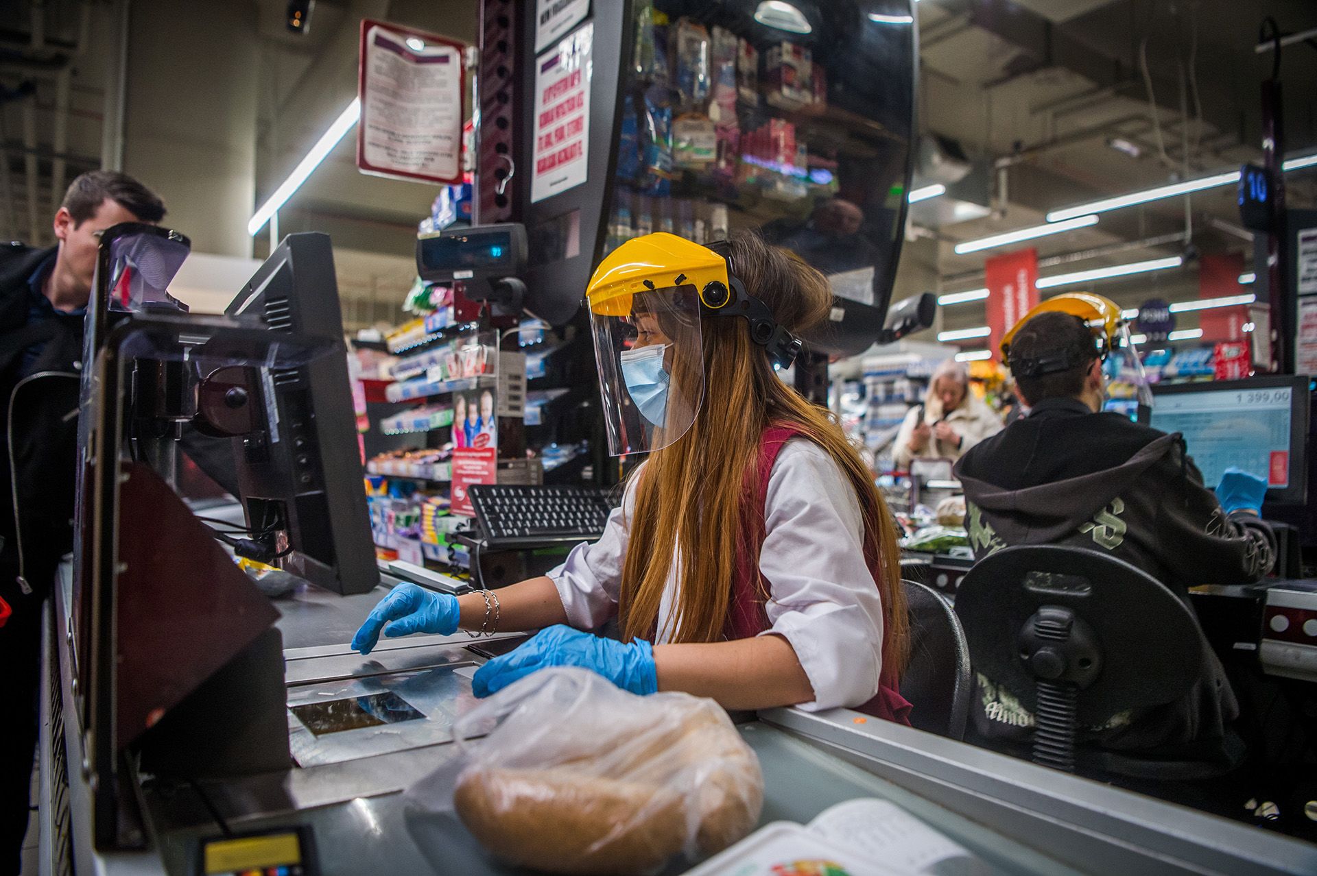 Pénztáros védőmaszkban egy fővárosi CBA üzletben a kijárási korlátozás előtti napon (fotó: MTI/Balogh Zoltán)