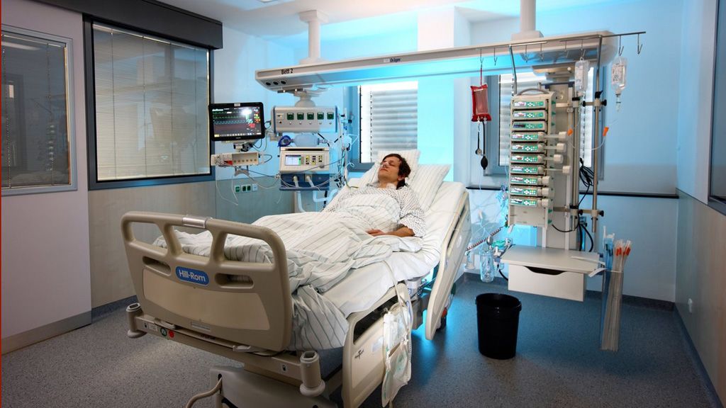 Férfi beteg lélegeztetőgépen fekszik egy kórteremben