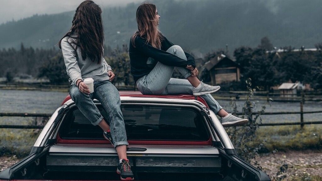 Két lány egy autó tetején.