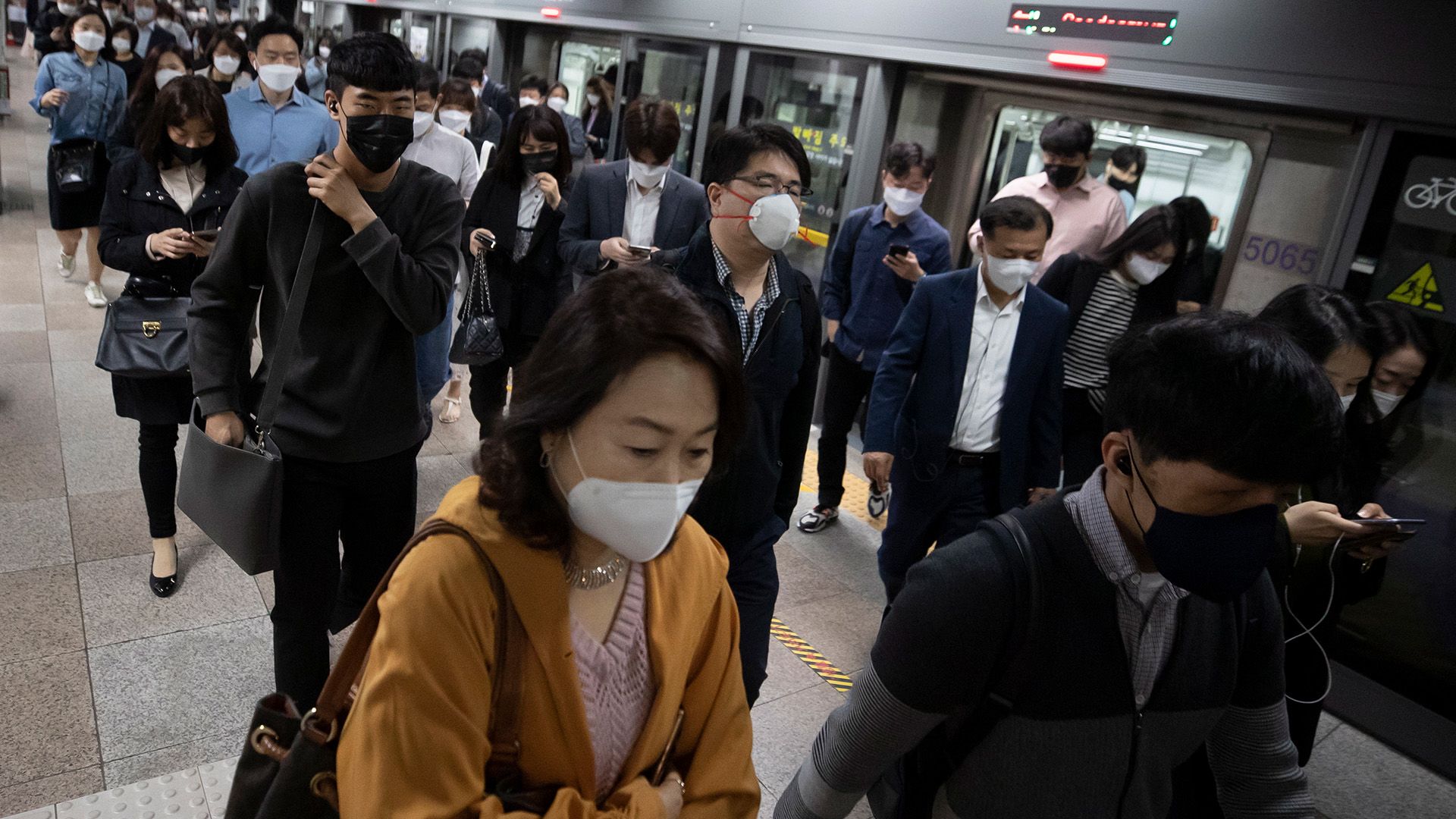 Maszkot viselő utasok a szöuli tömegközlekedésen