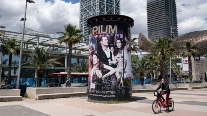 Maszkban biciklizik egy nő Barcelonában