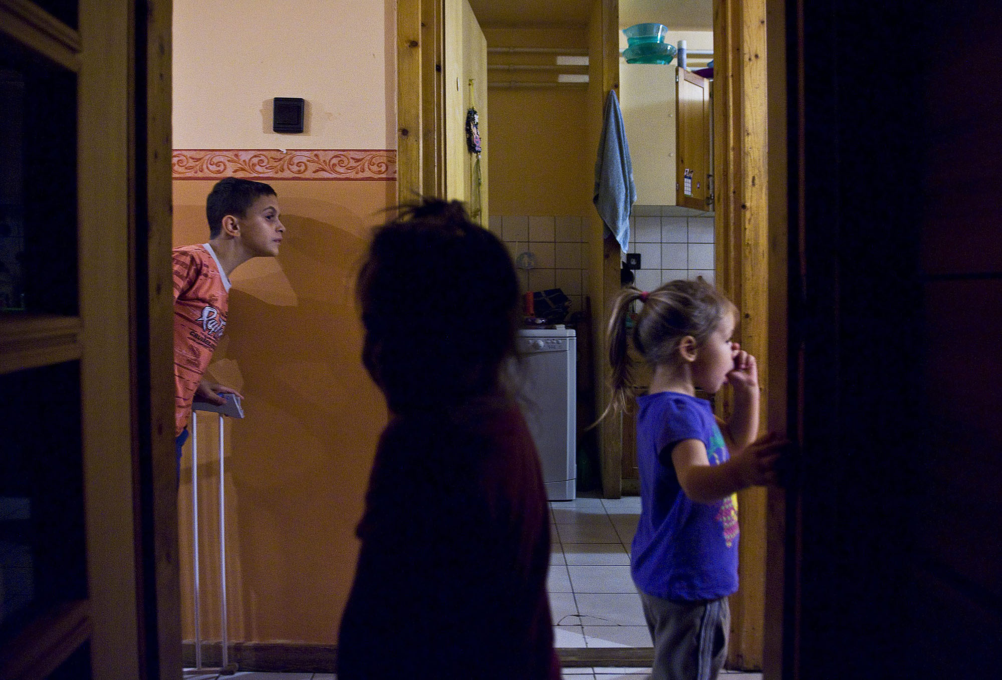 Gyerekek néznek be a folyosóról a konyhába vacsora előtt az SOS Gyermekfalu Magyarországi Alapítványának kecskeméti gyermekfalujában (fotó: MTI/Ujvári Sándor)