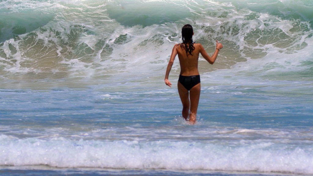 Félmeztelen strandoló a tengerben