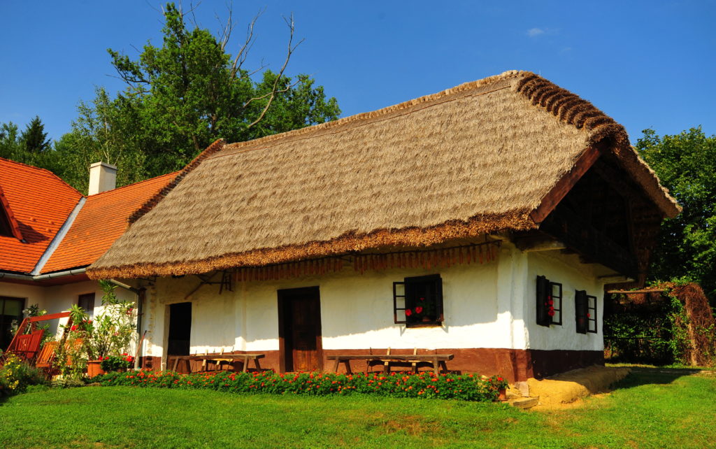 Egy - az eredeti helyén - felújított zsúpfedeles, döngölt agyagpadlós, boronafalú, füstös konyhás népi műemlék épület. (Kétvölgy)