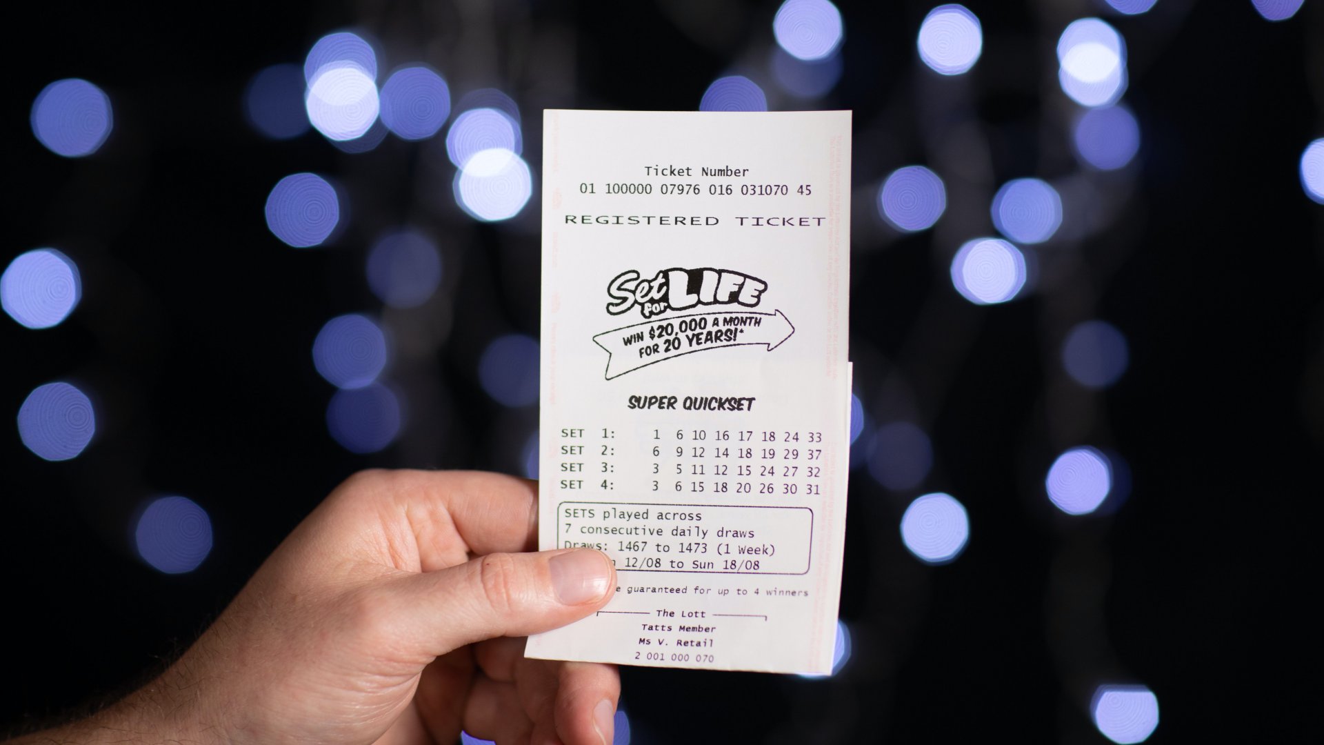 Lottószelvényt mutat egy kéz