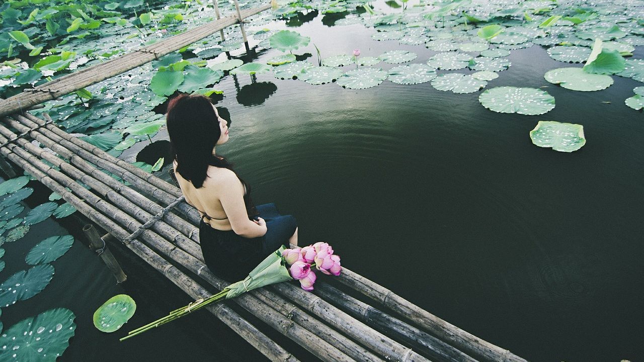 Tónál üldögélő nő virággal