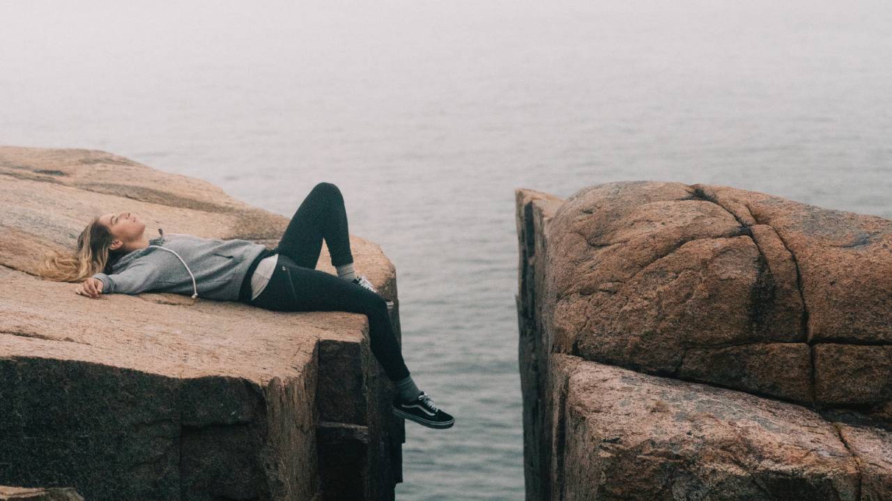 nő sziklán fekszik