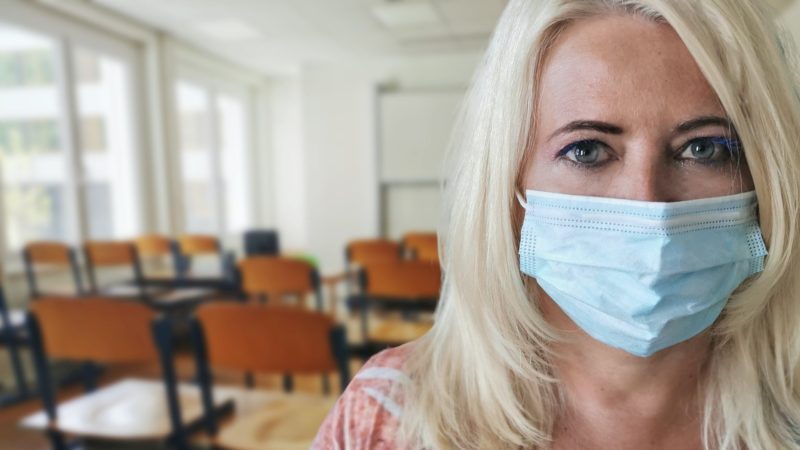 Maszkot viselő tanárnő az osztályteremben