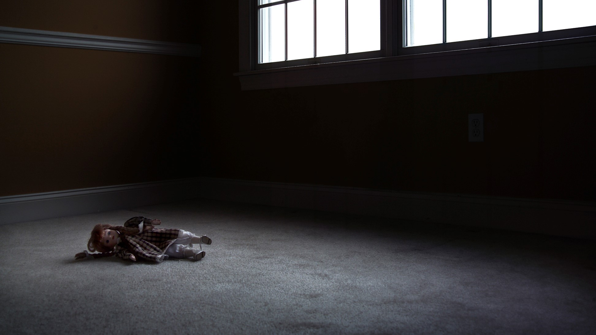 Játékbaba egy üres szobában