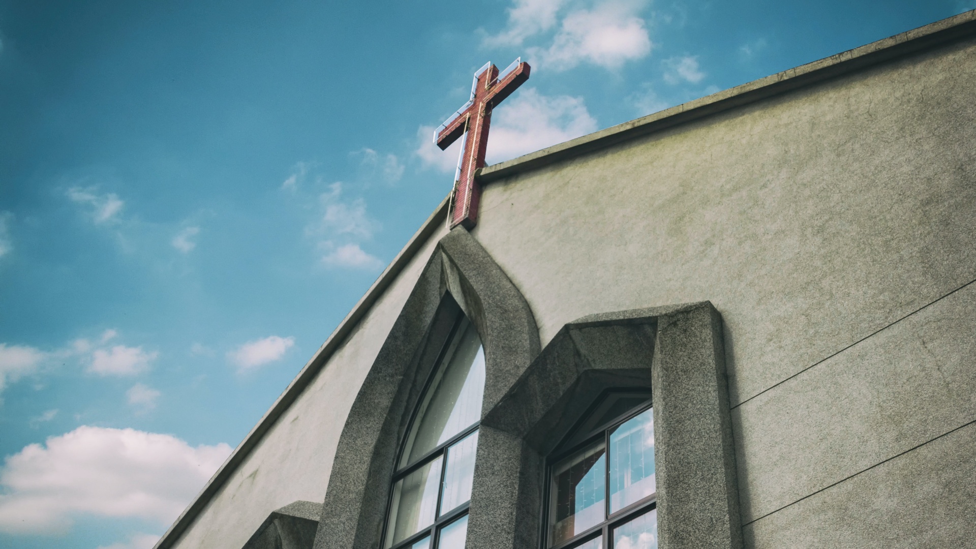 Egy templom homlokzata hatalmas kereszttel a tetején