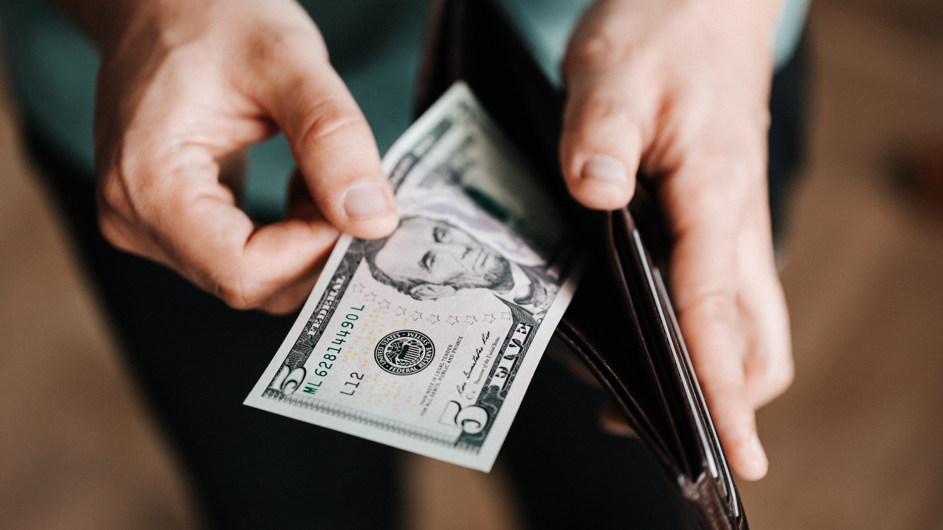 Kivesz egy ötdolláros bankjegyet a pénztárcából