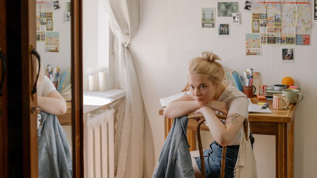 Fiatal nő gondolkodik a szobájában