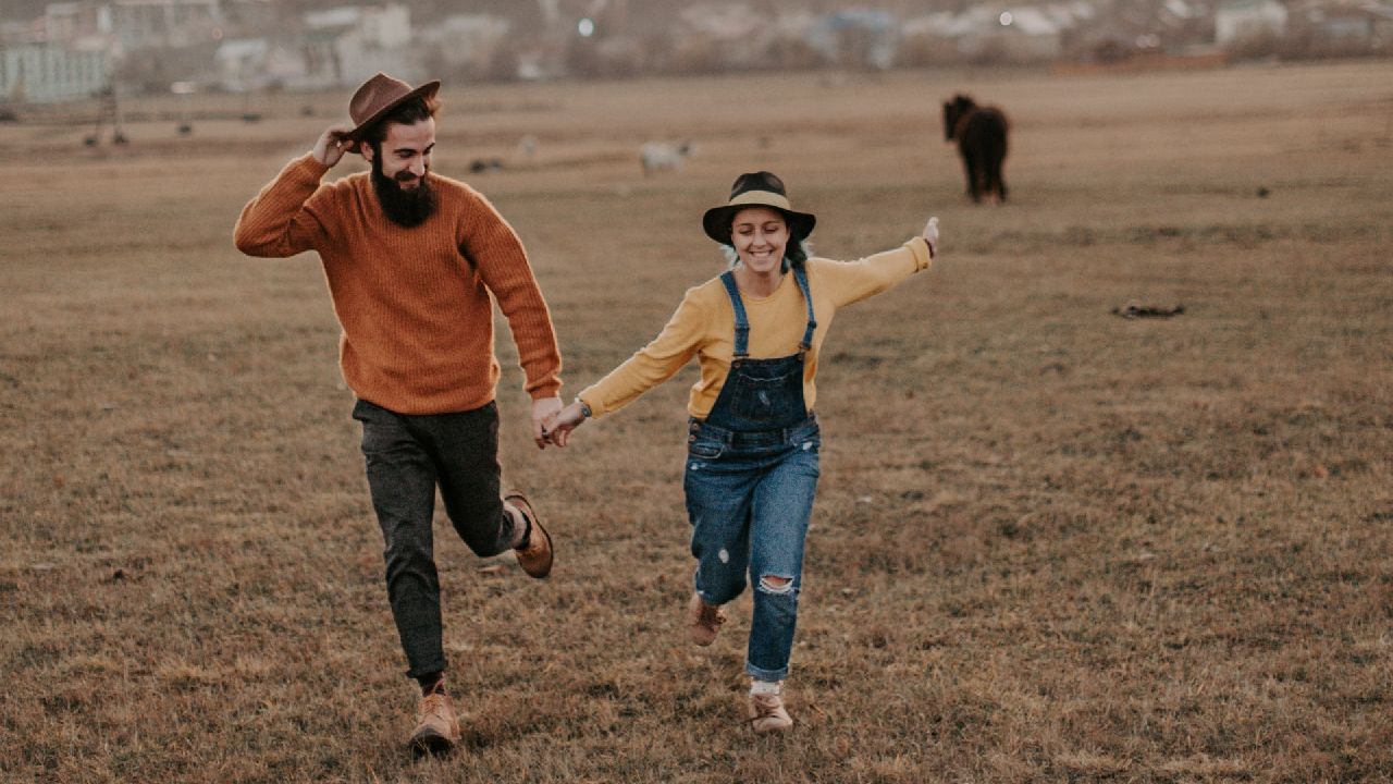 Szerelmespár fut a réten