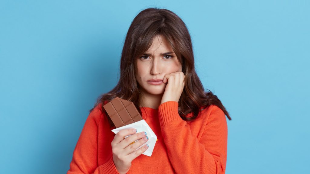 Nő egy megbontott tábla csokoládéval
