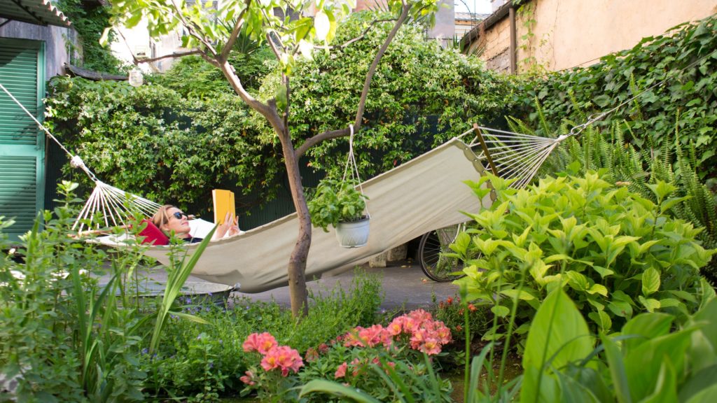 Egy nő hintaágyban olvas a kertben