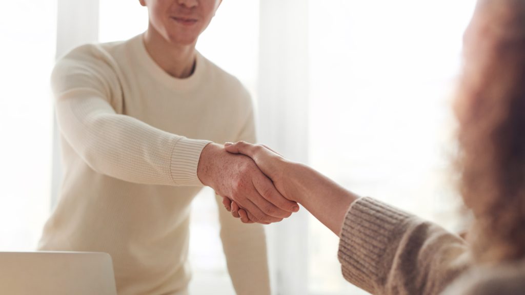 Egy férfi és egy nő kezet fog egy állásinterjún
