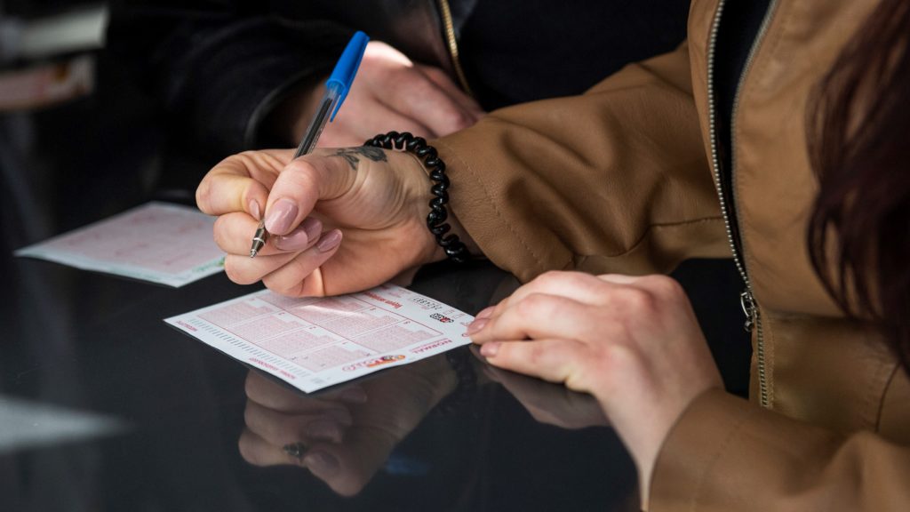 Lottószelvényt töltenek ki a Szerencsejáték Zrt. Csalogány utcai lottózójában Budapesten