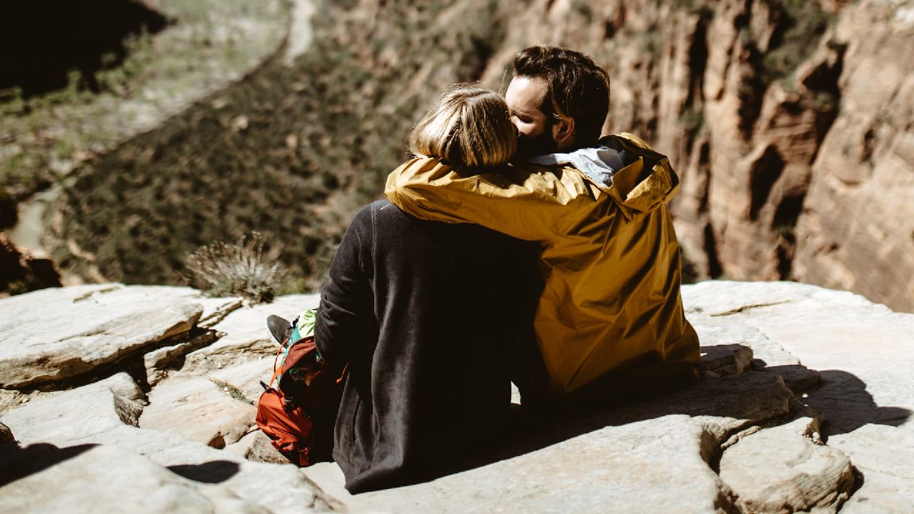 Szerelmespár a sziklafalon üldögél