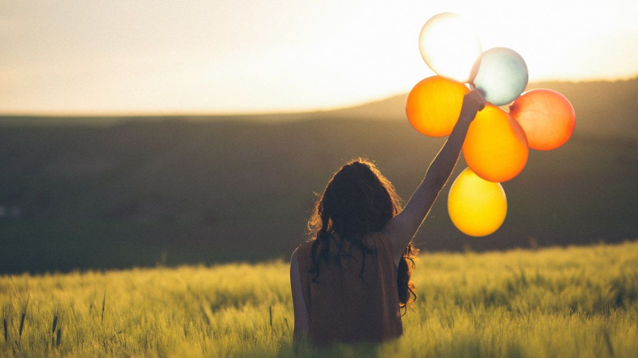 Lány lufival a mezőn