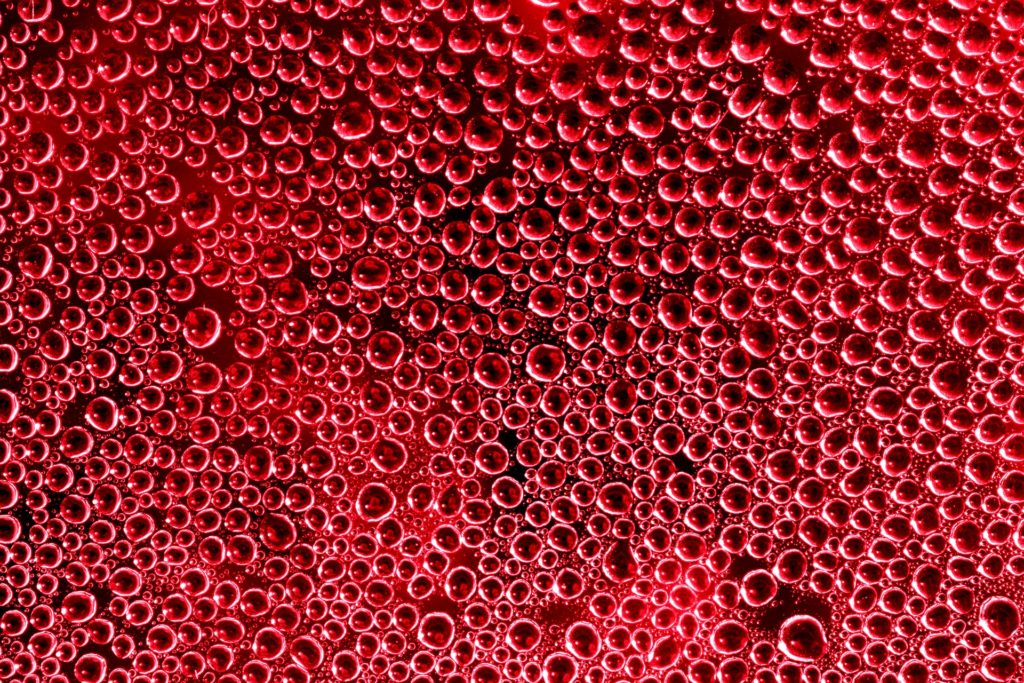 Vízcseppek piros háttér előtt 