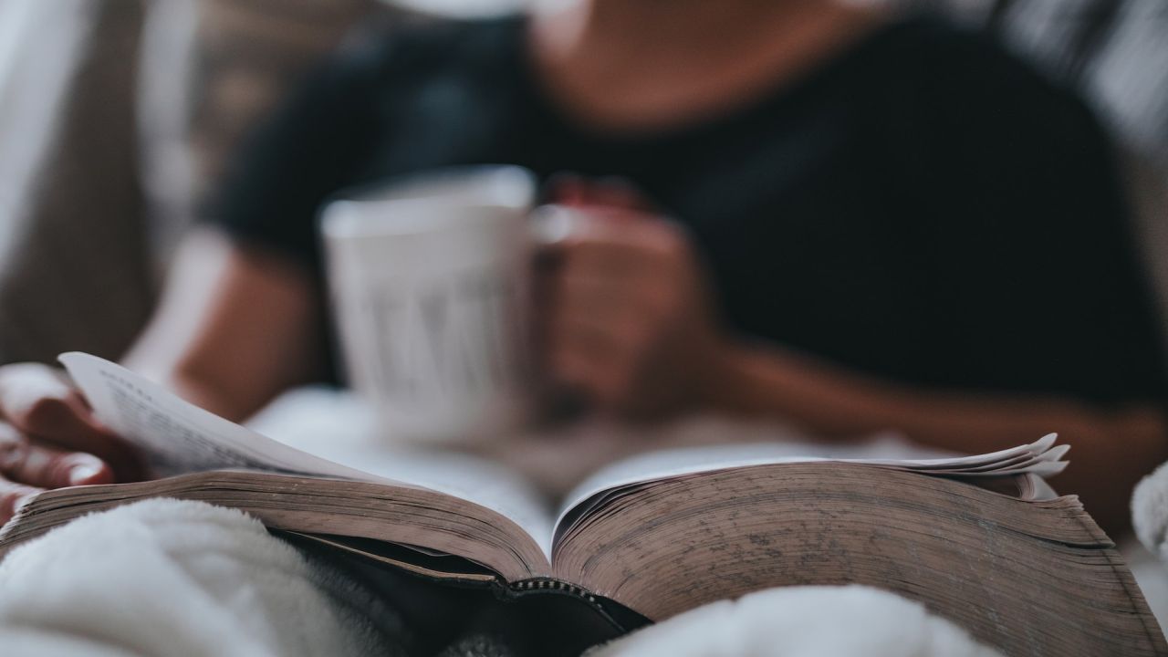 Nagy könyvvel és csészével heverészve