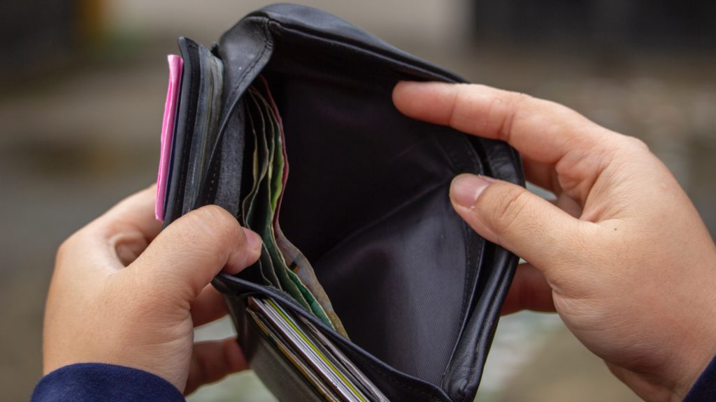 Férfi belenéz a pénztárcájába