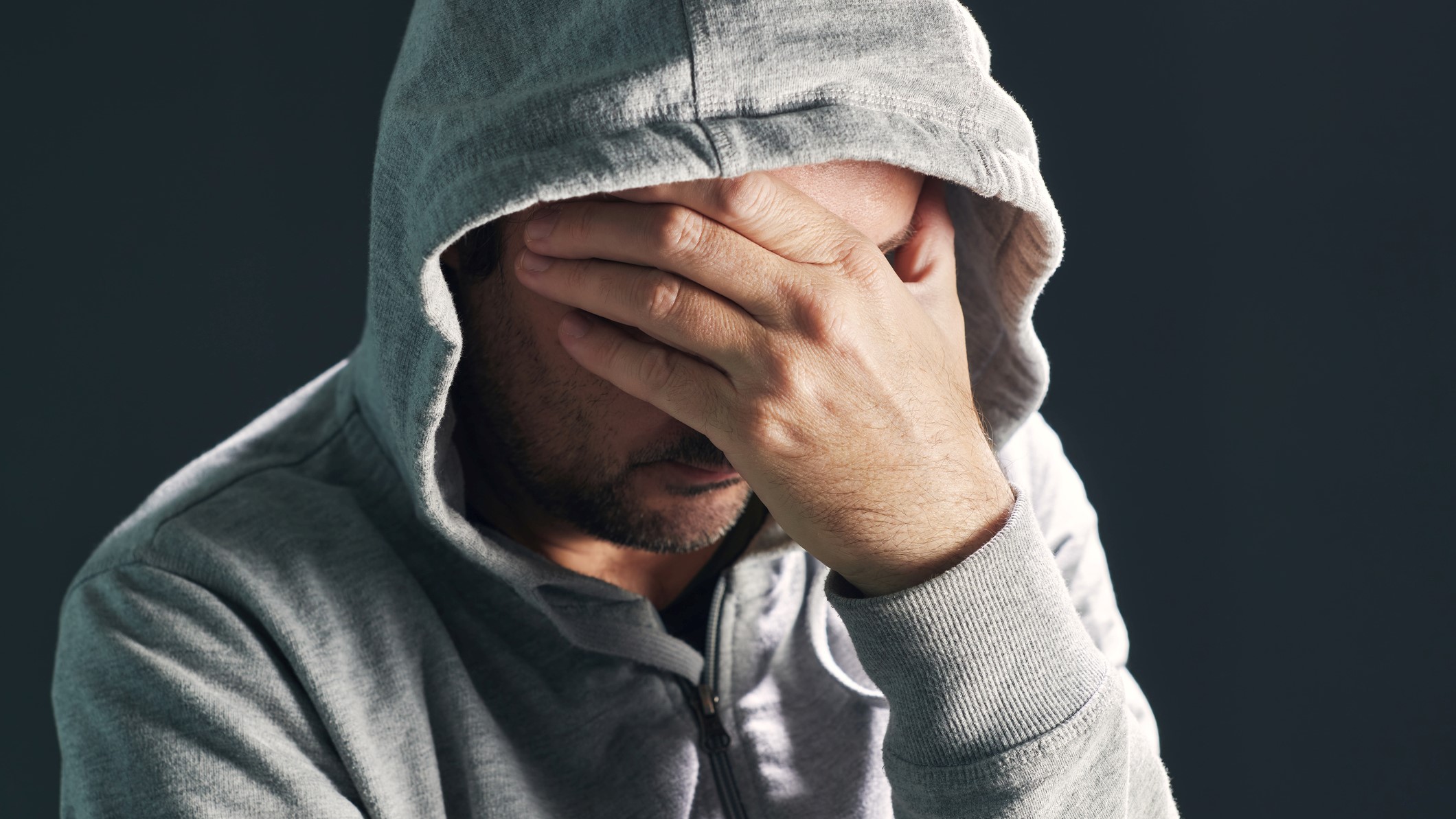 Egy férfi eltakarja az arcát