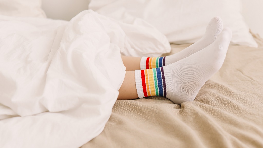 Ágyban fekvő, zoknis nő