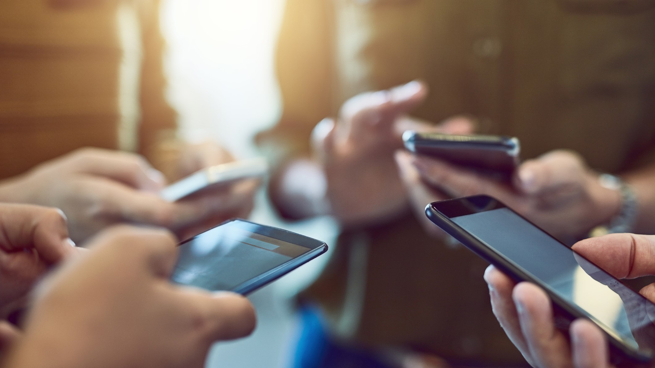 Egy csoport mobiltelefont tart a kezében