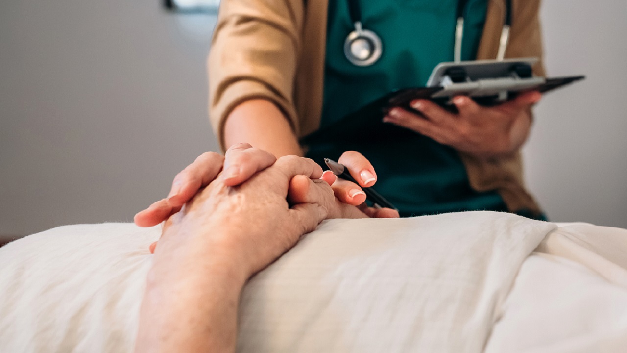 Haldokló kezét fogja egy orvos