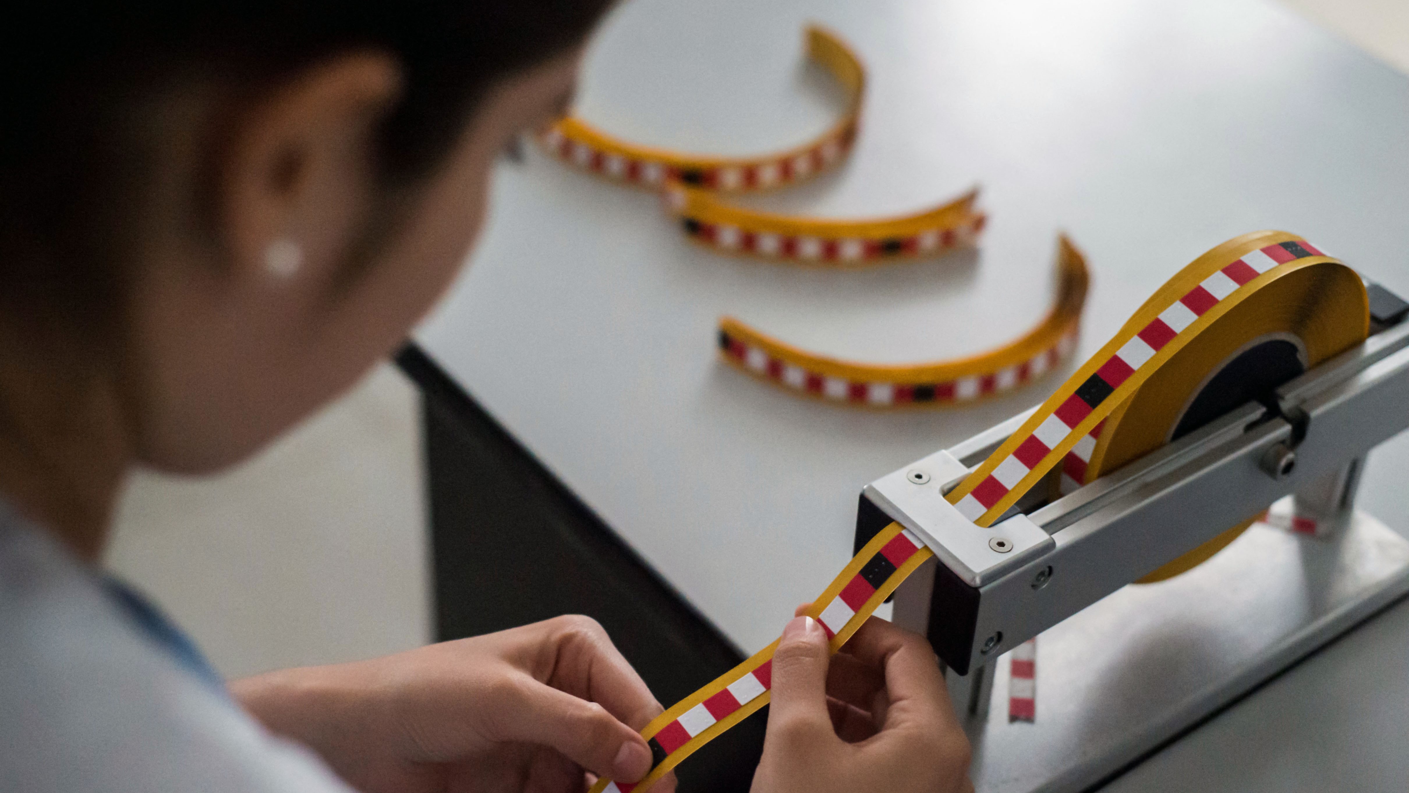 Leidy Garcia előkészíti a Braille-írással jelölt szalagcsíkokat, amelyeket a mellvizsgálatok elvégzéséhez használnak egy kolumbiai kórházban