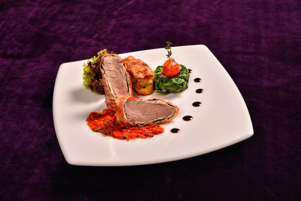 Baconbe tekert szűzpecsenye rozmaringgal ízesített paradicsomszósszal, pancettával és sajttal töltött burgonyával, párolt bébispenóttal