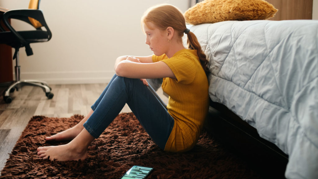 Lehangolt lány az ágya mellett