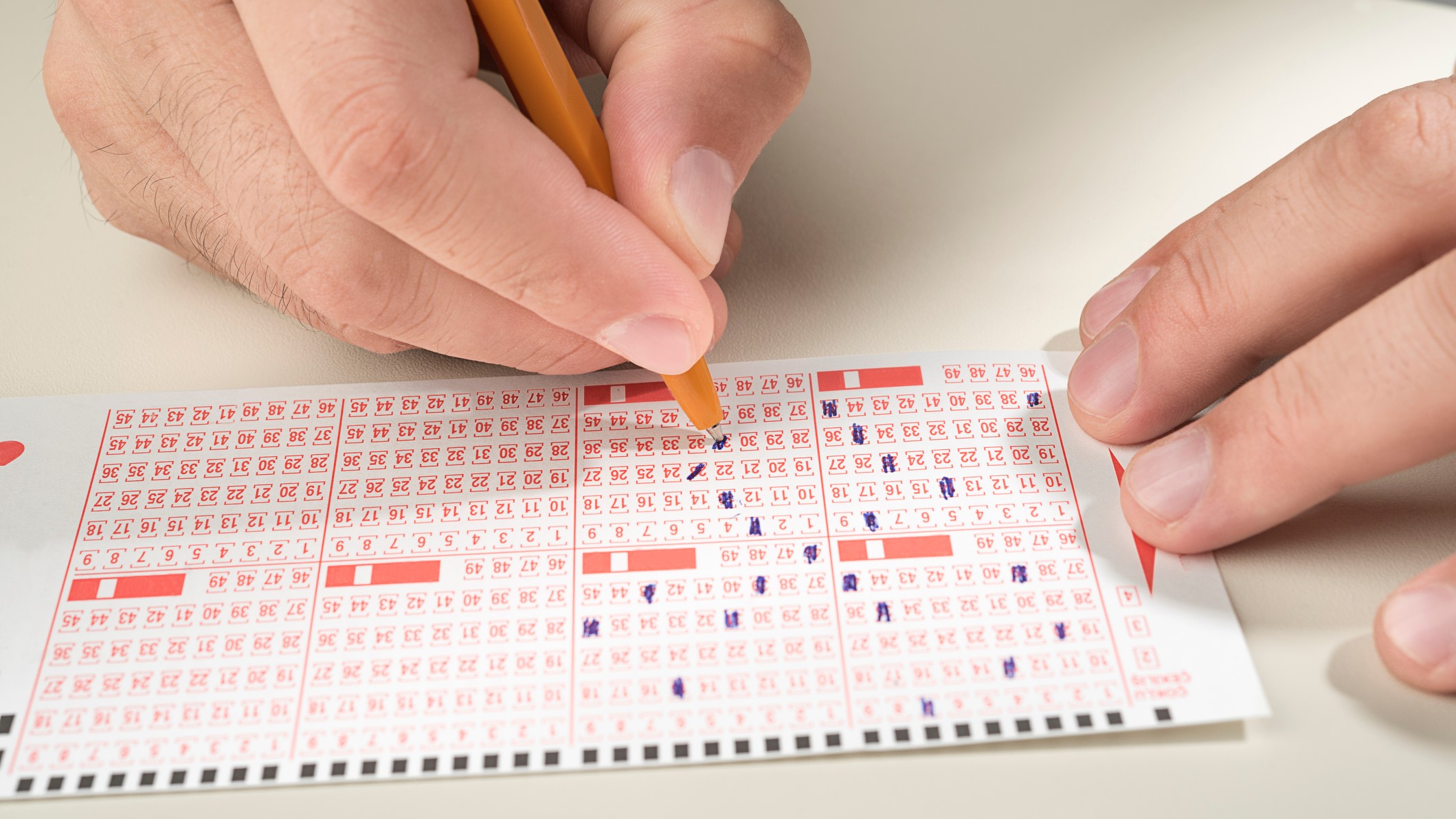 Lottószelvényt tölt ki egy férfi