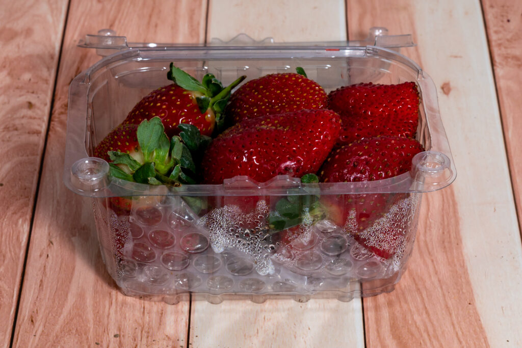 Érett eper párás műanyagdobozban