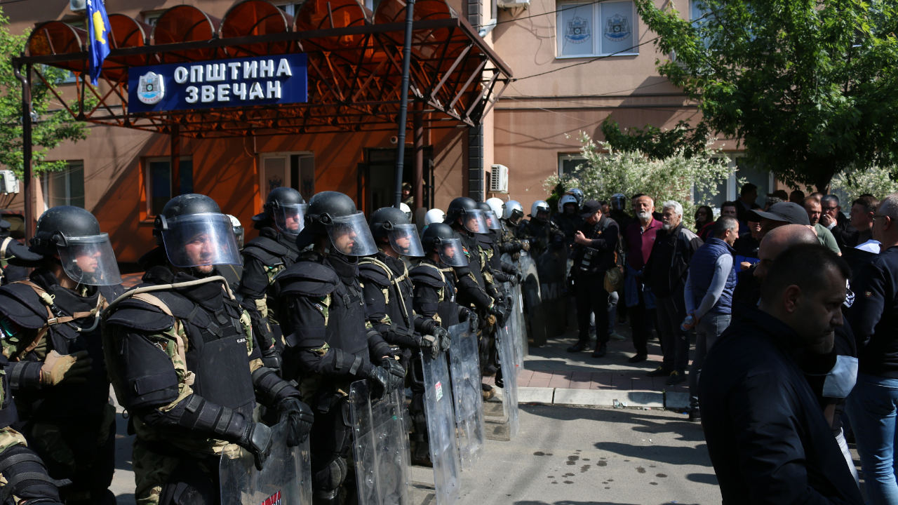 A koszovói rendőrség különleges egységei védik az önkormányzat épületét a szerb tüntetőktől az albániai új polgármester elleni akciójukon a koszovói Mitrovicában 2023. május 29-én.