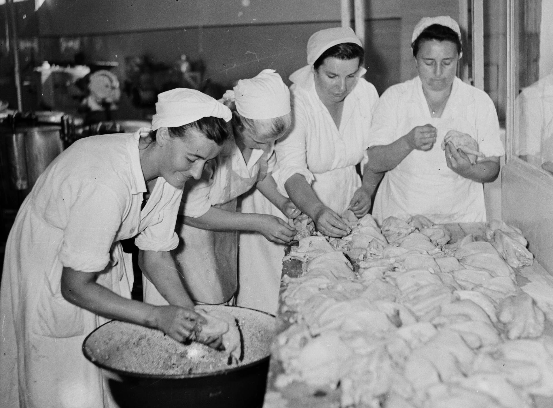 Asszonyok tyúkot tisztítanak a konyhában