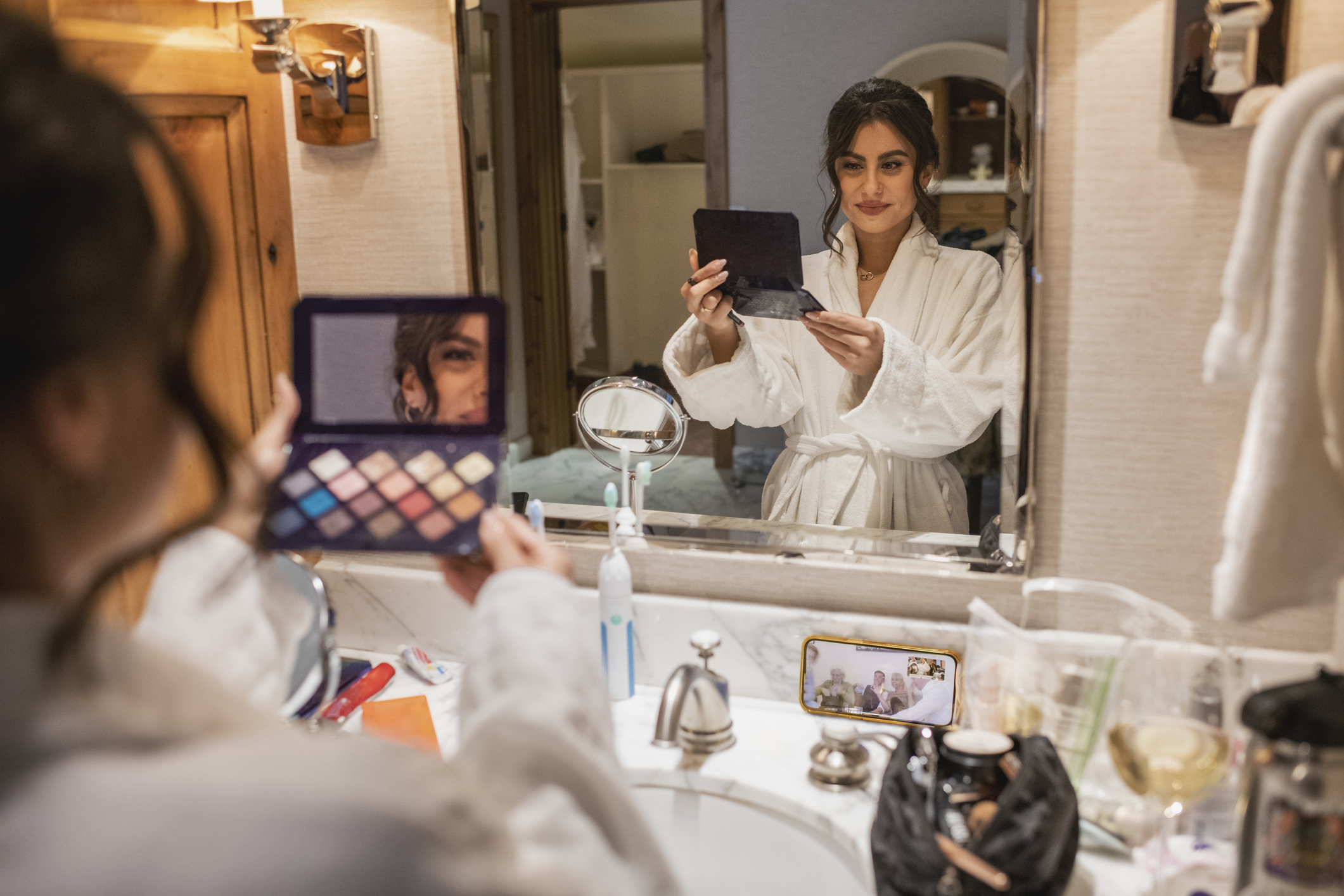 Az esküvője előtt álló menyasszony a fürdőben készíti a sminkjét. Épp a színpalettát nézi.