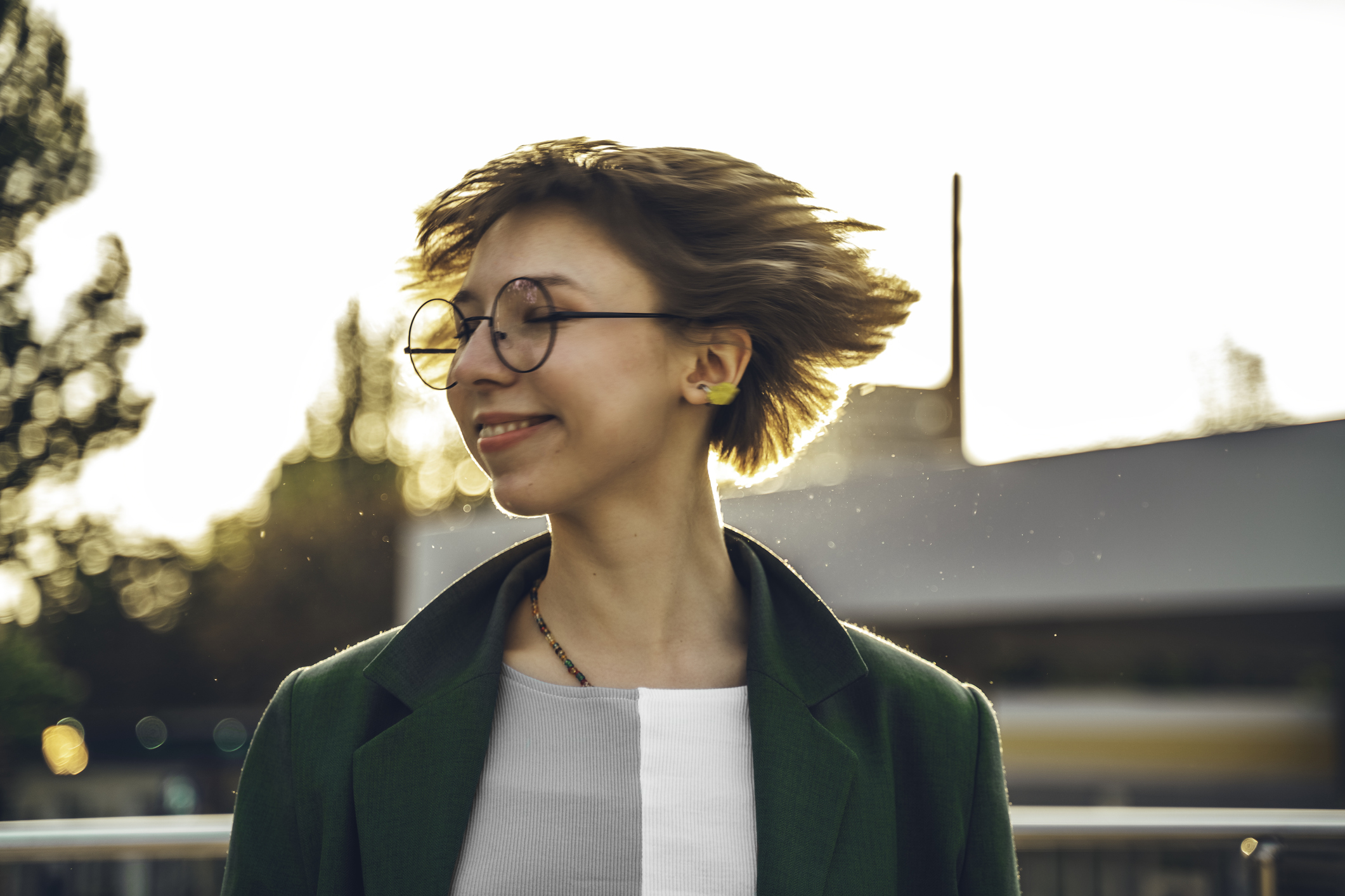 Fiatal szemüveges lány megrázza rövid haját.