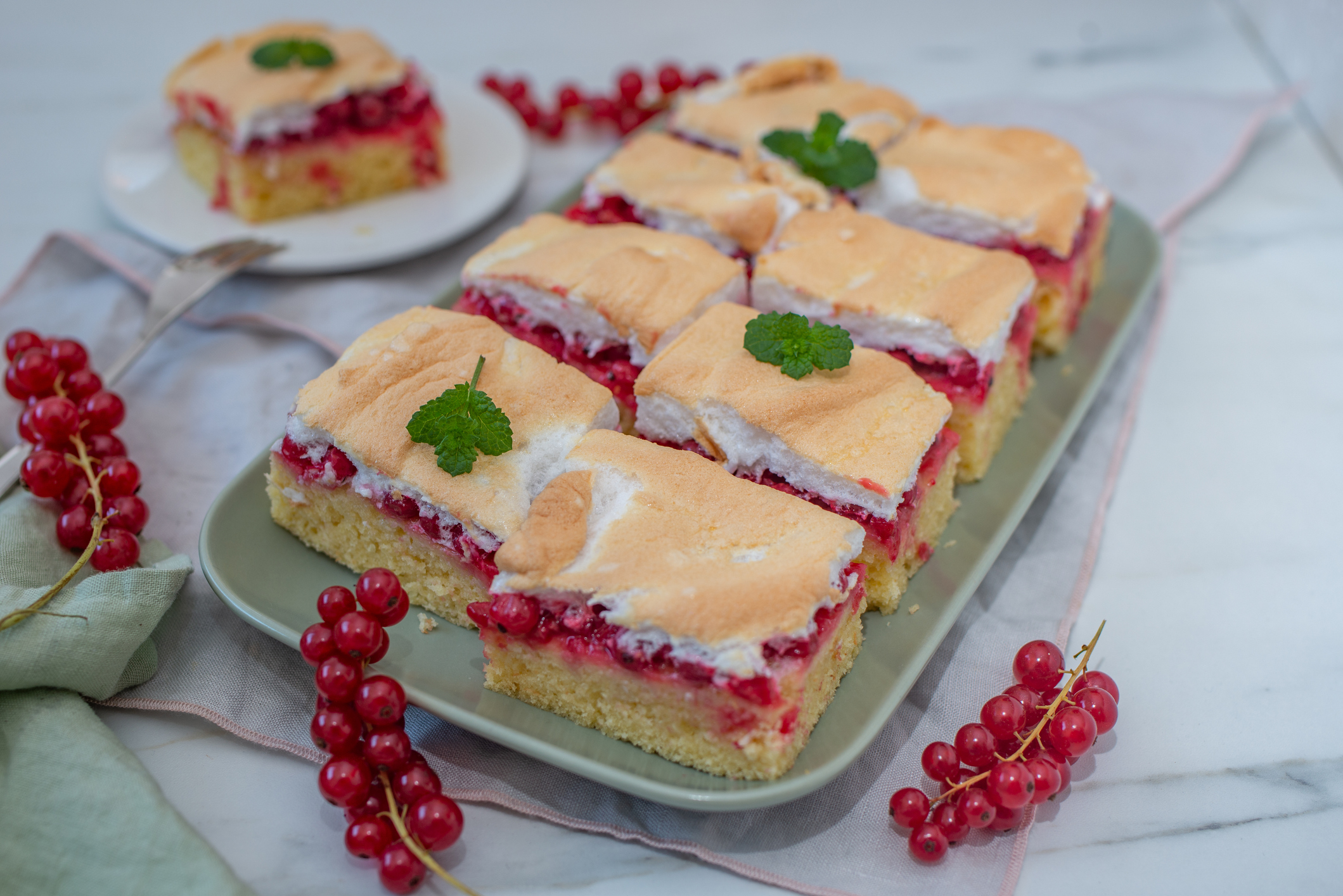 Tejbegrízes ribizlis sütemény felvágva az asztalon.